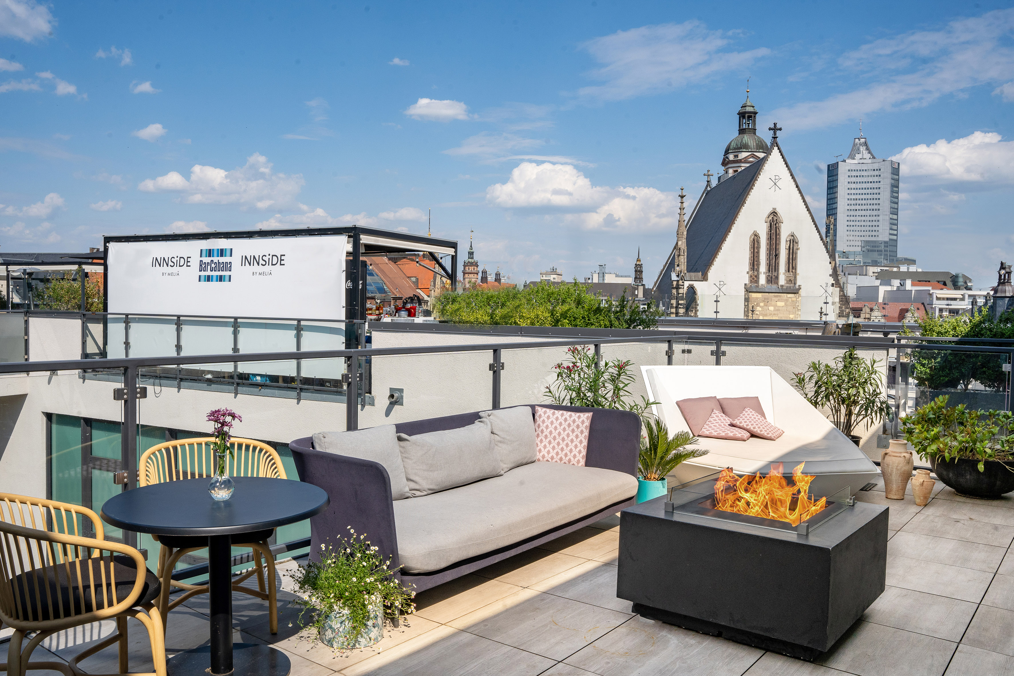 INNSiDE hotel rooftop bar, Leipzig city view, lounge seating, fire pit.