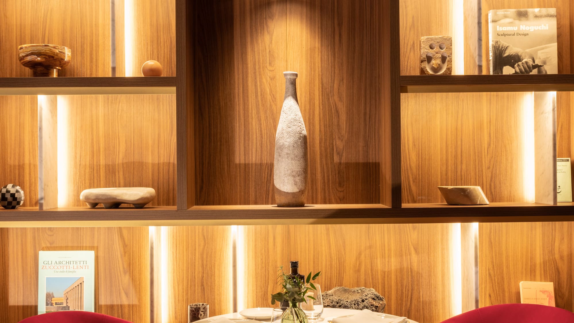 a table with red chairs and a vase on top of it