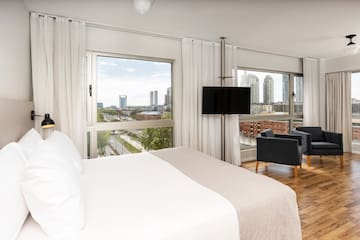 a bedroom with a large window and a large bed