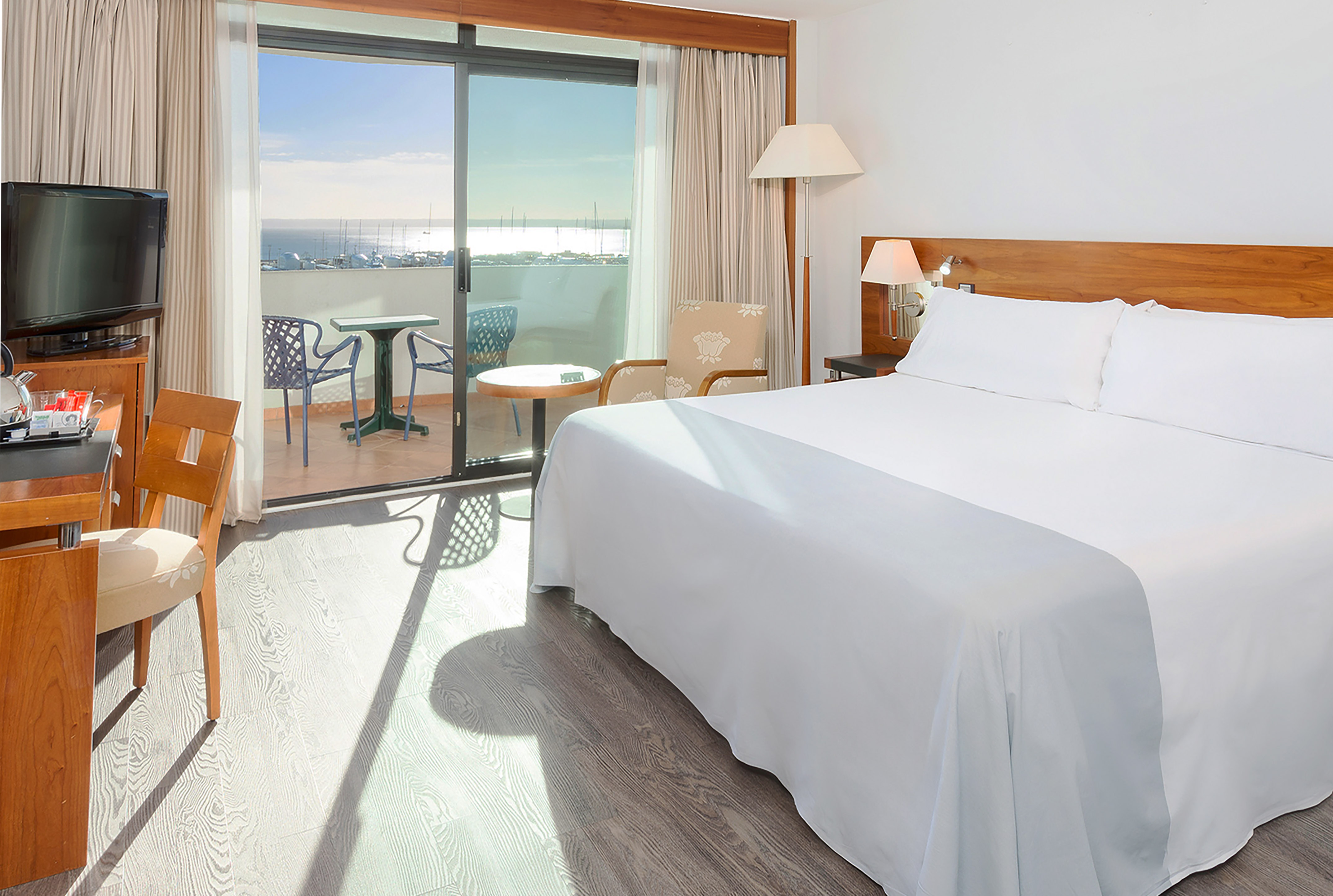 Hotel room with king bed, balcony, sea view, and marina vista.