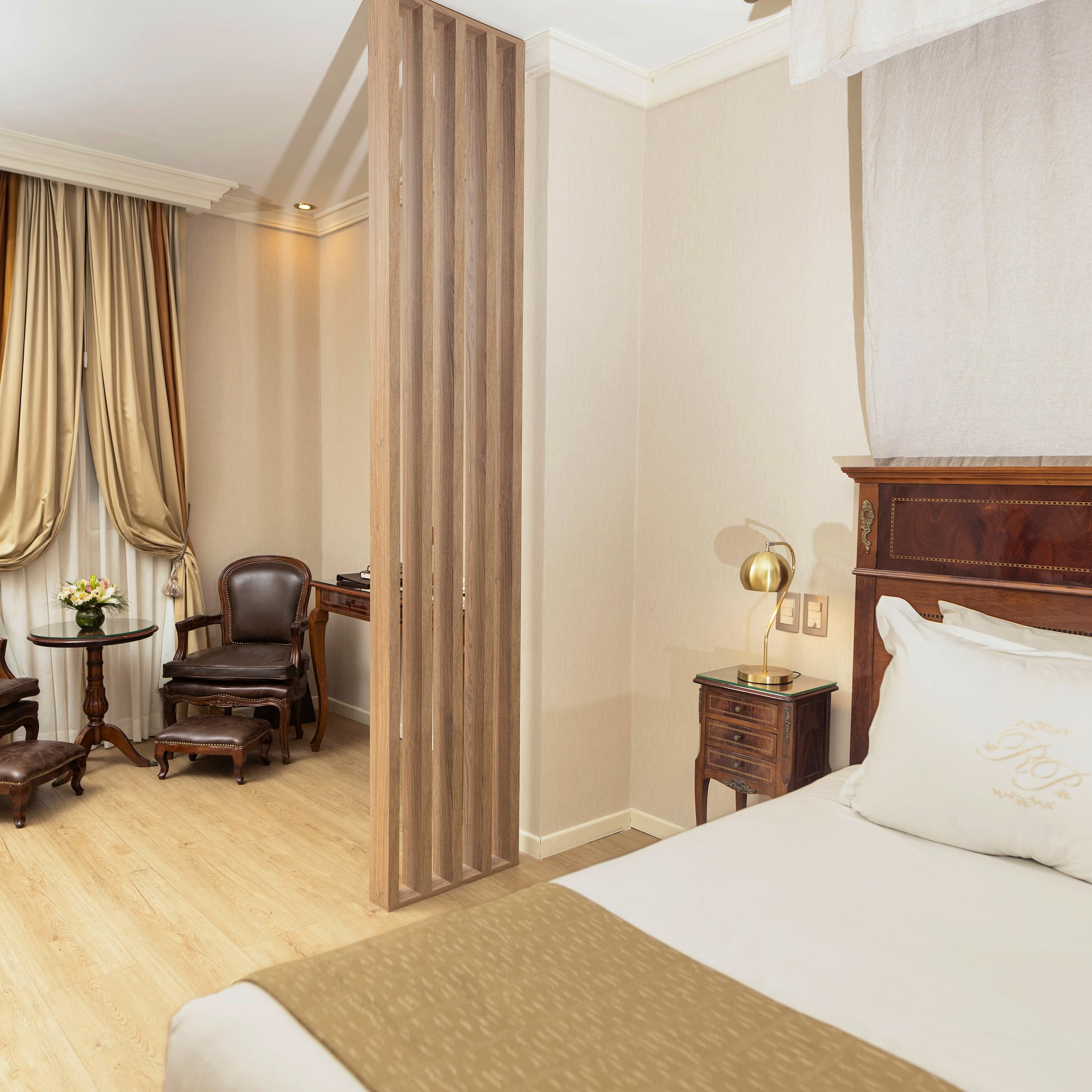 a room with a bed and chairs