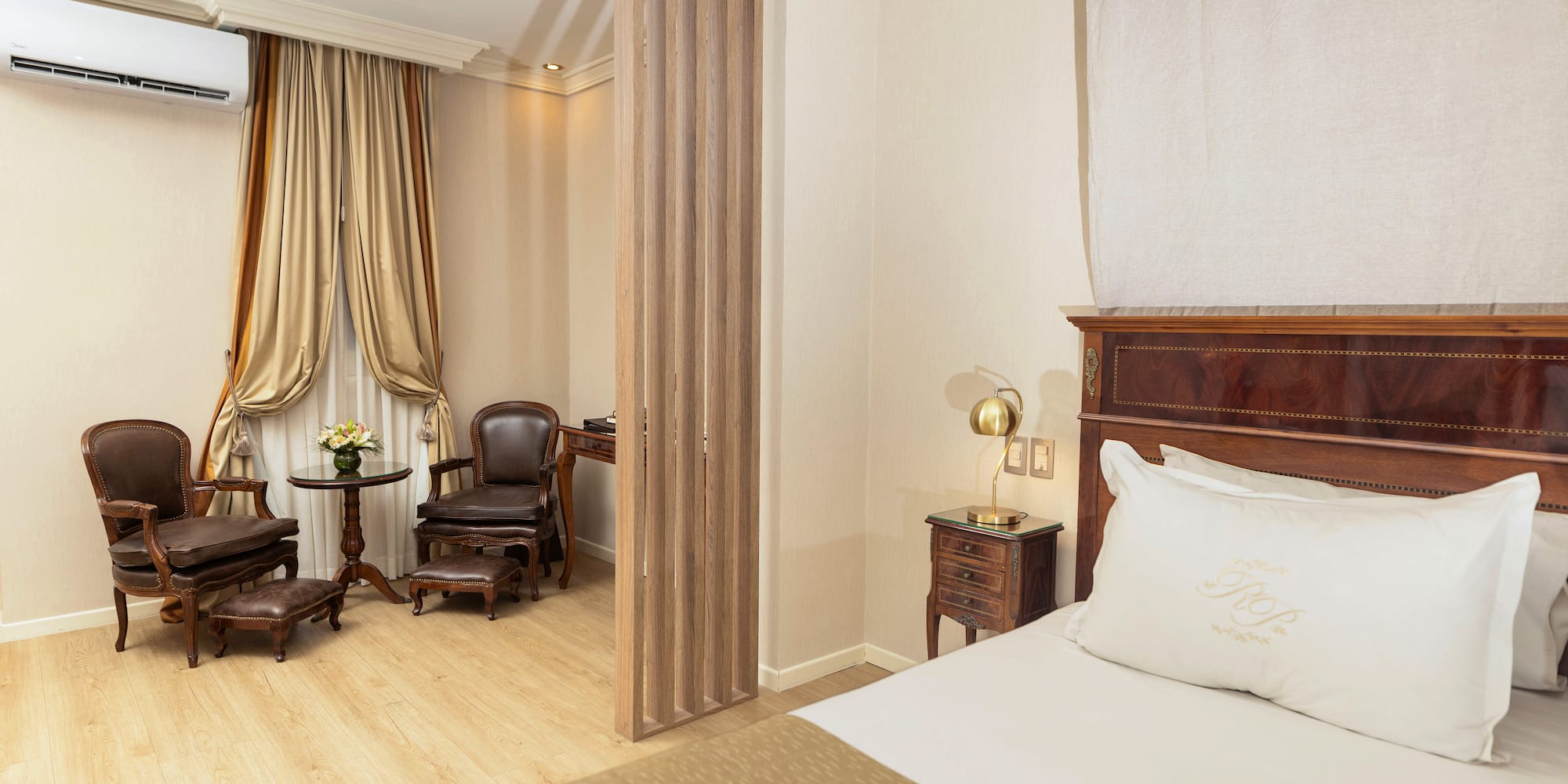 a room with a bed and chairs