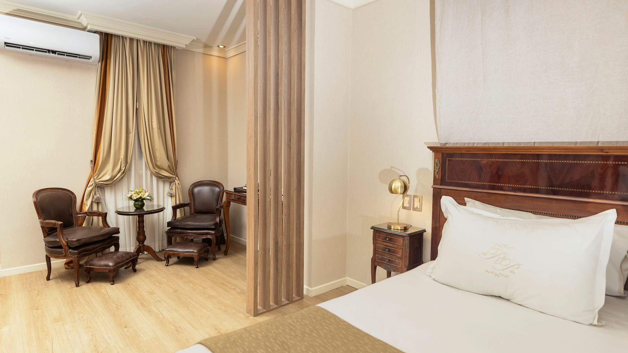 a room with a bed and chairs