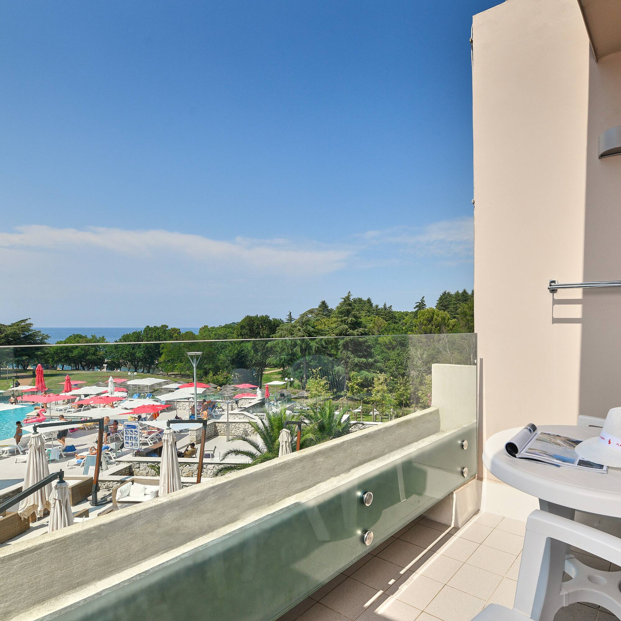 a balcony with a view of a pool and a table