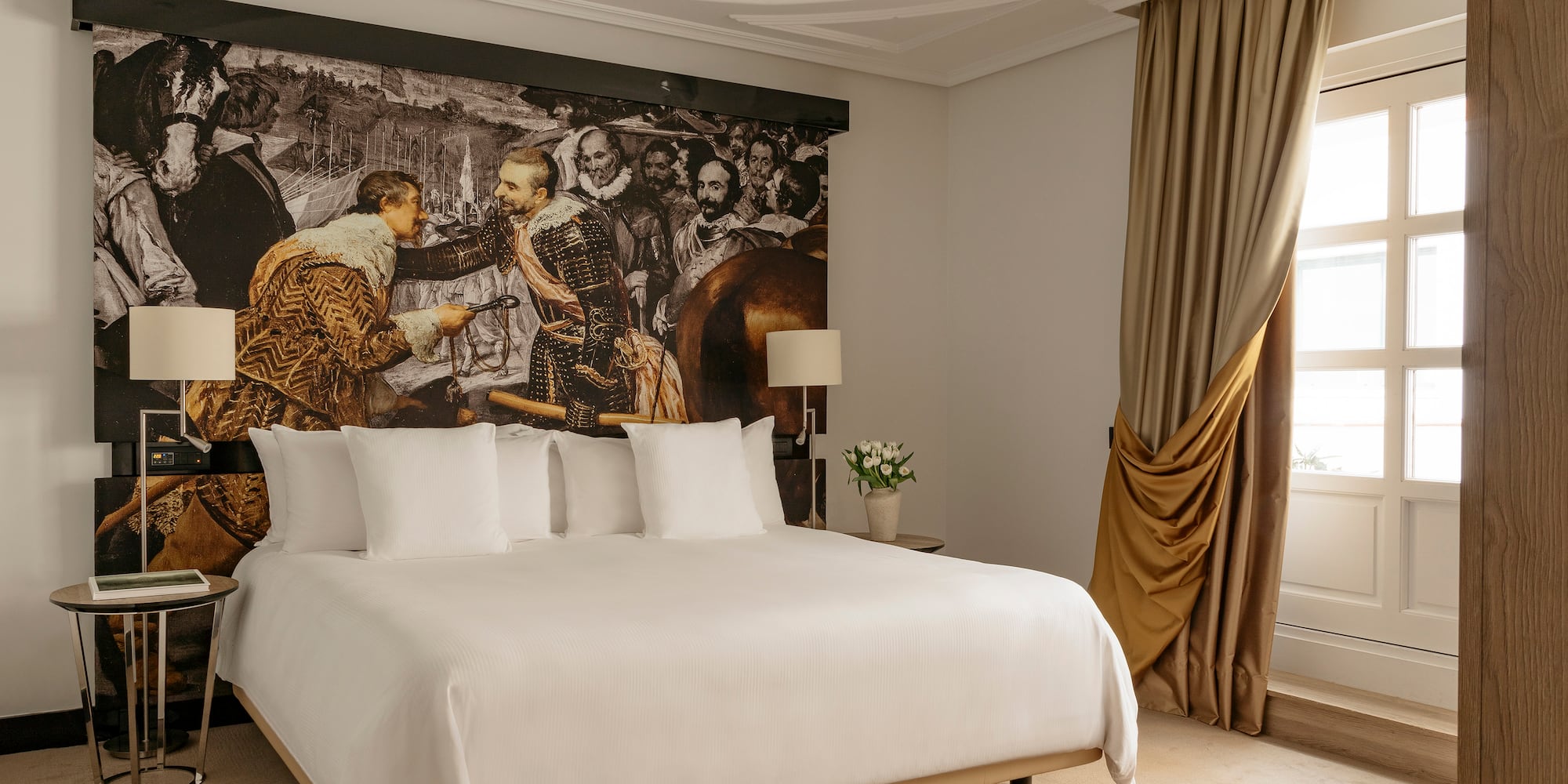 a bed with a large picture on the wall