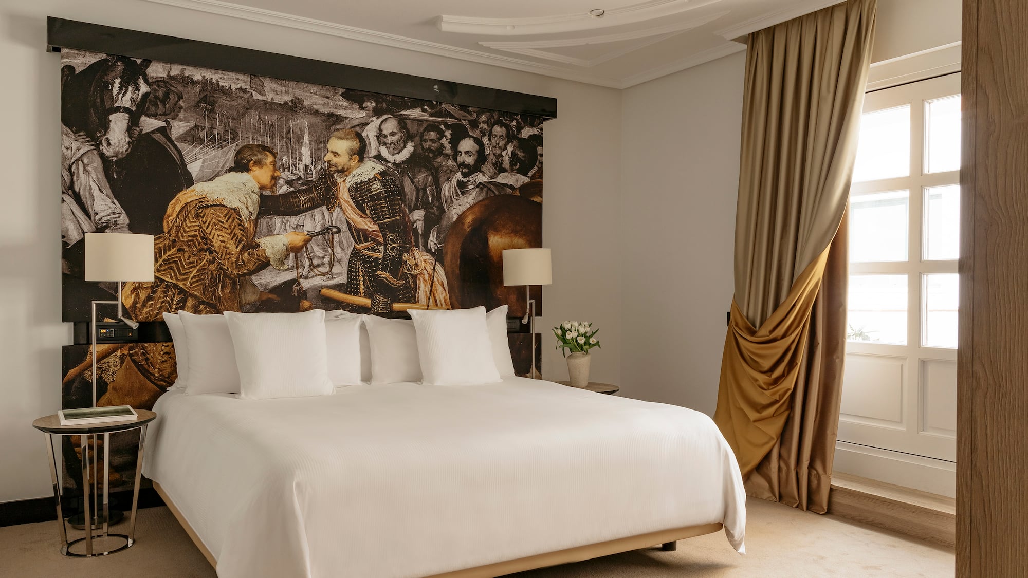 a bed with a large picture on the wall