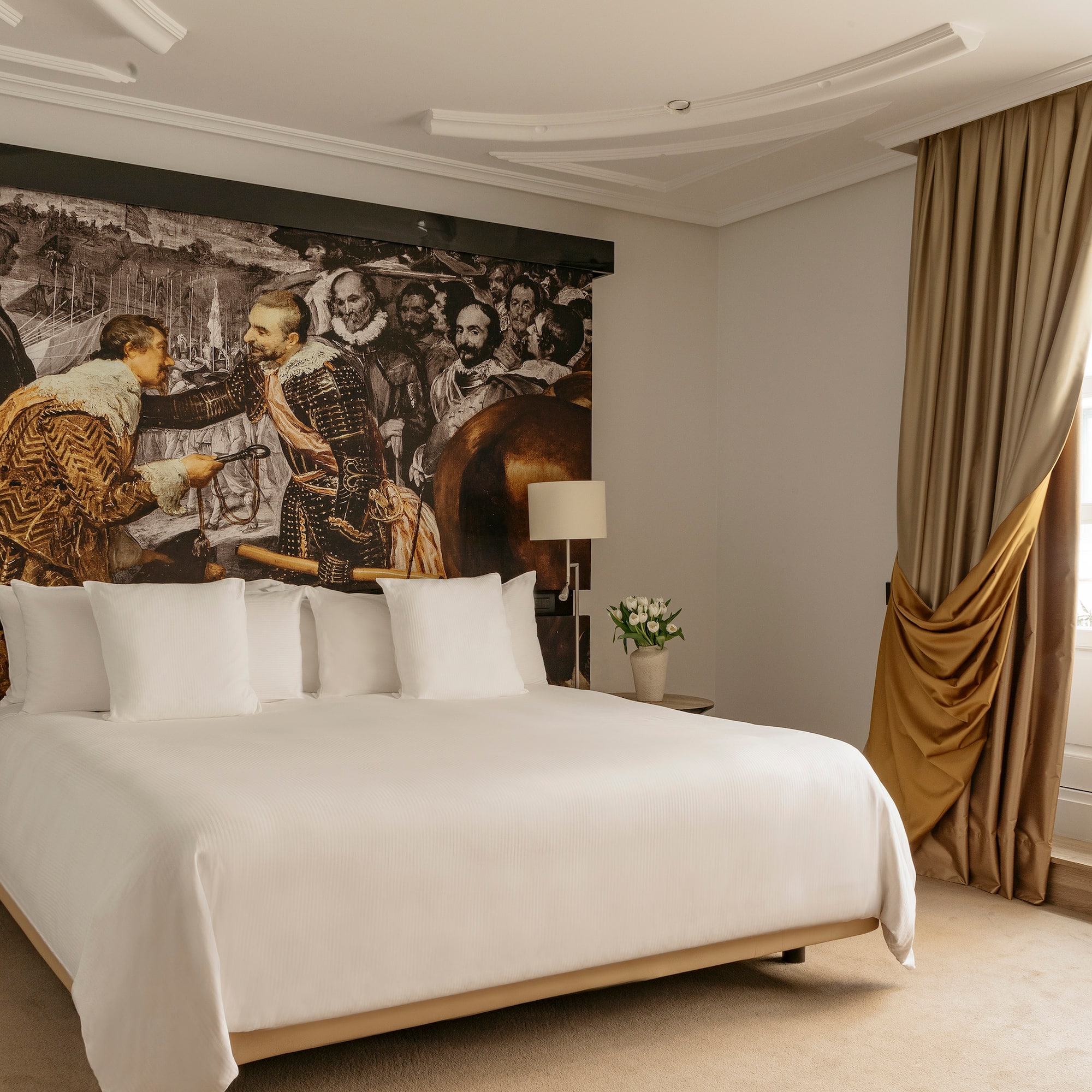 a bed with a large picture on the wall