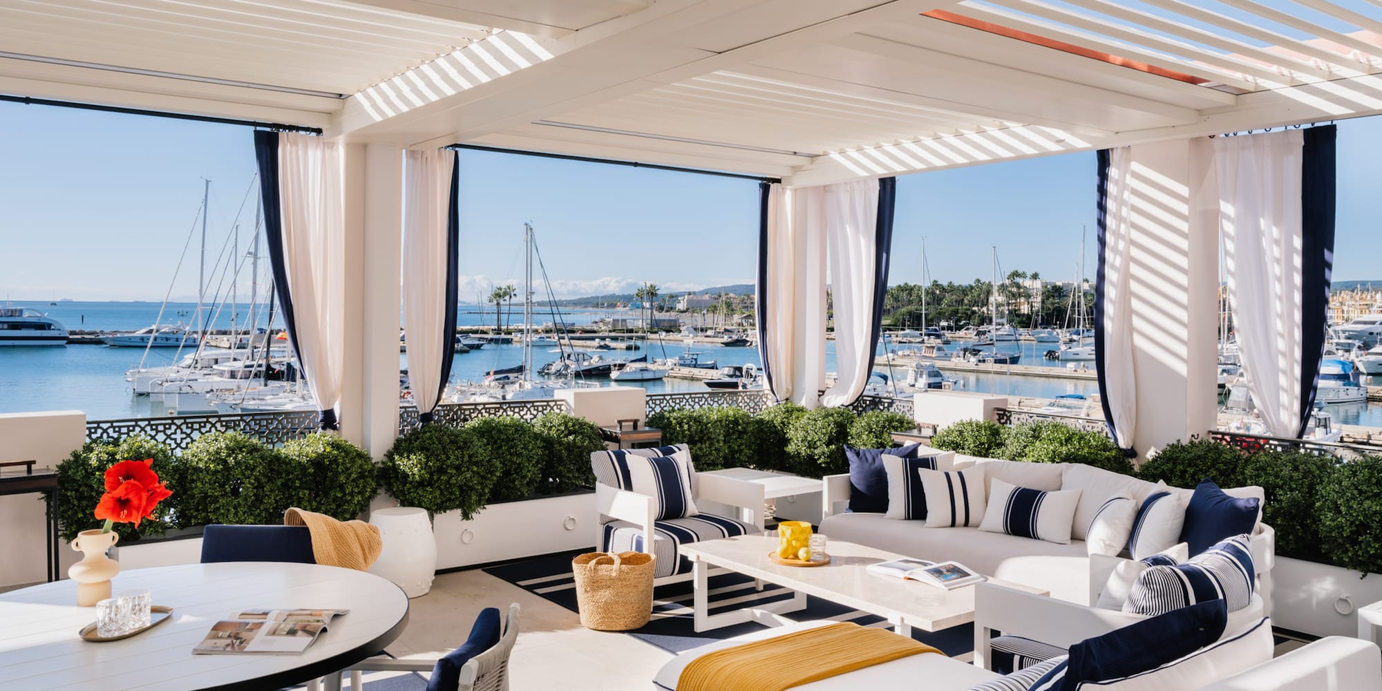 a white and blue outdoor patio with a table and chairs