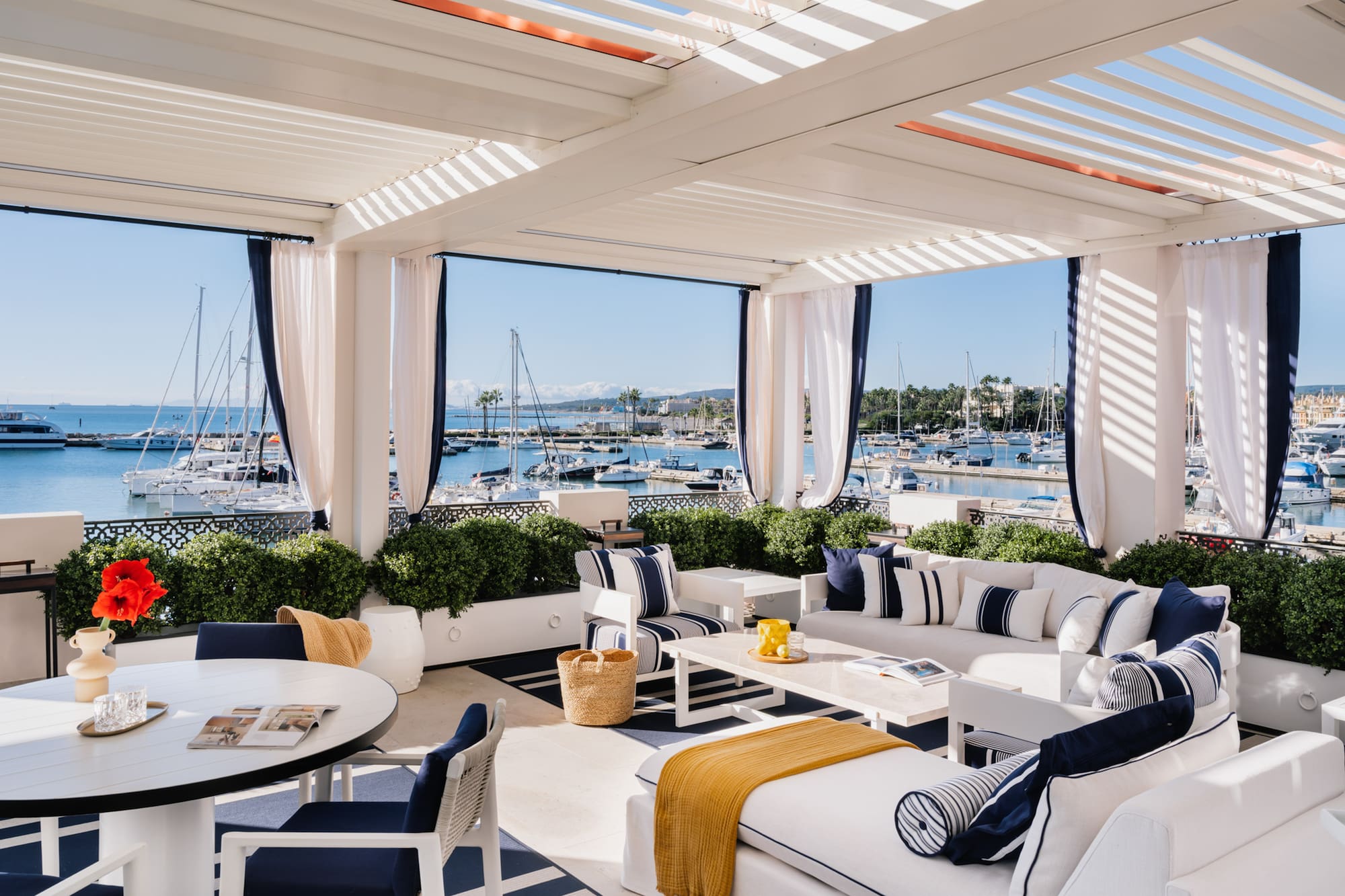 a white and blue outdoor patio with a table and chairs