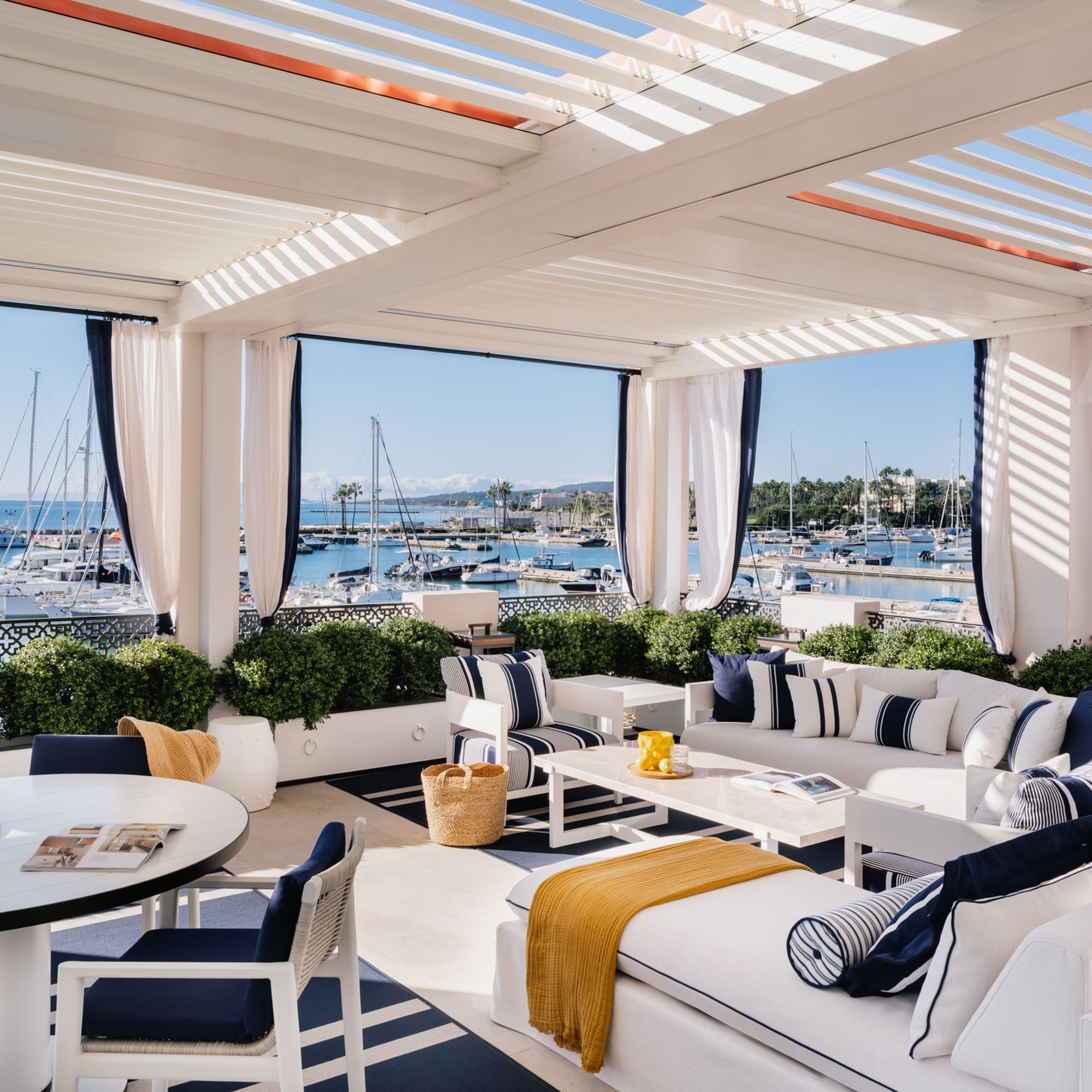 a white and blue outdoor patio with a table and chairs