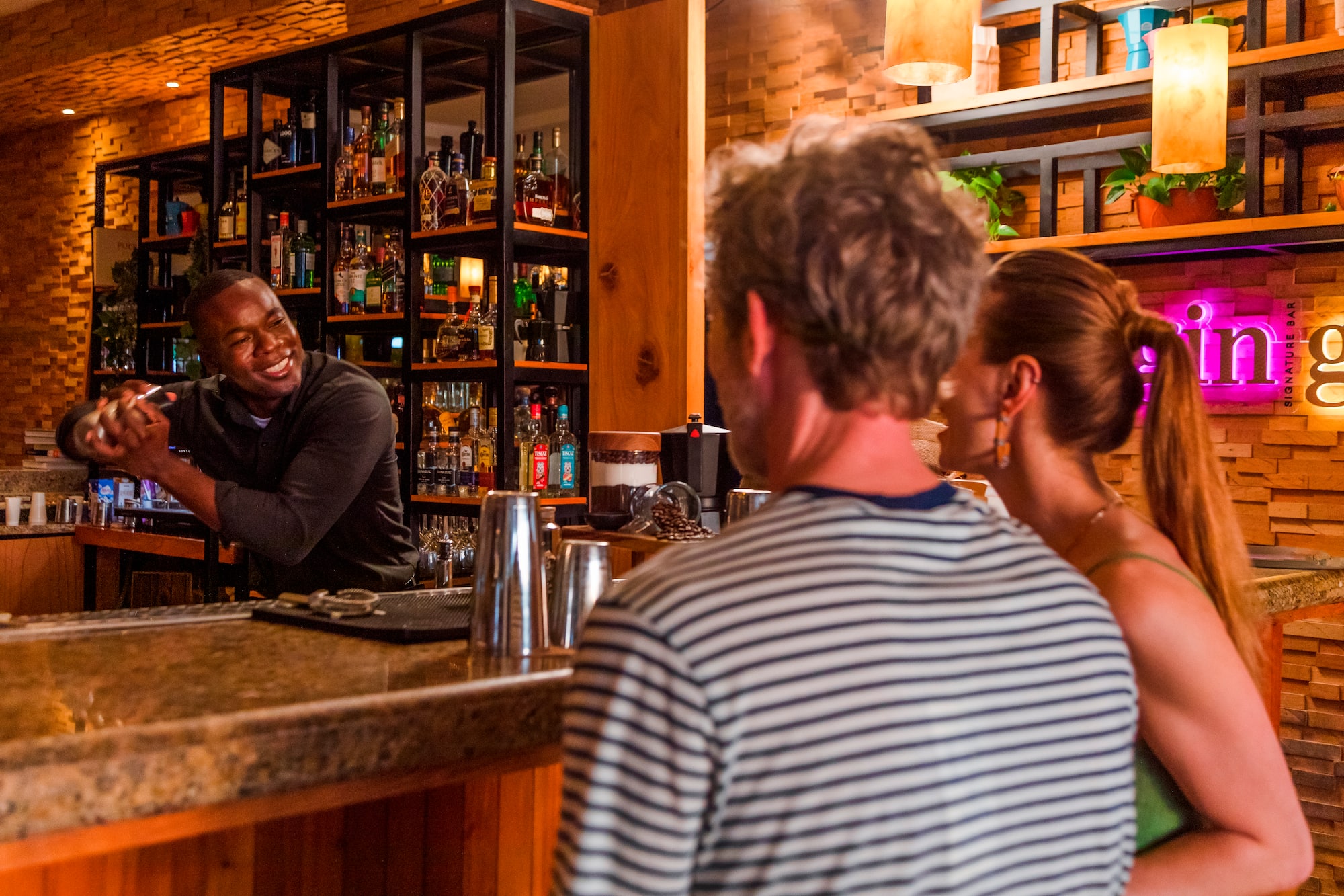 a man standing behind a counter with a bartender behind him