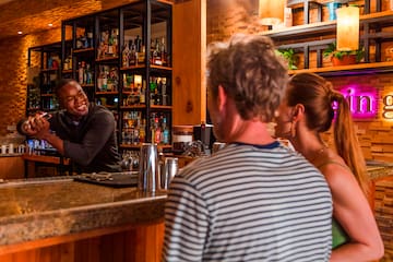 a man standing behind a counter with a bartender behind him