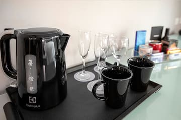 a black kettle and cups on a black tray