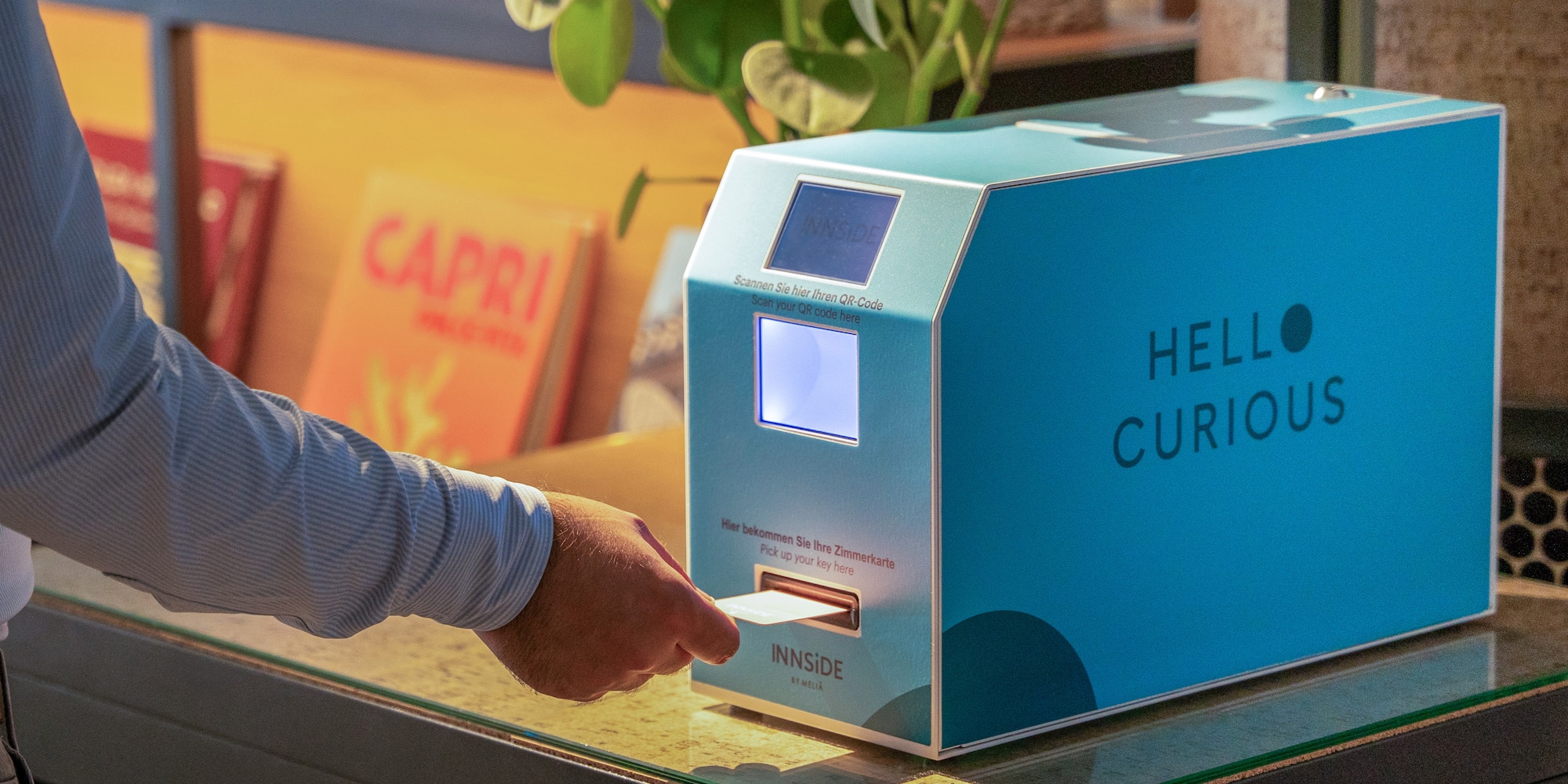 a person's hand pressing a paper into a machine