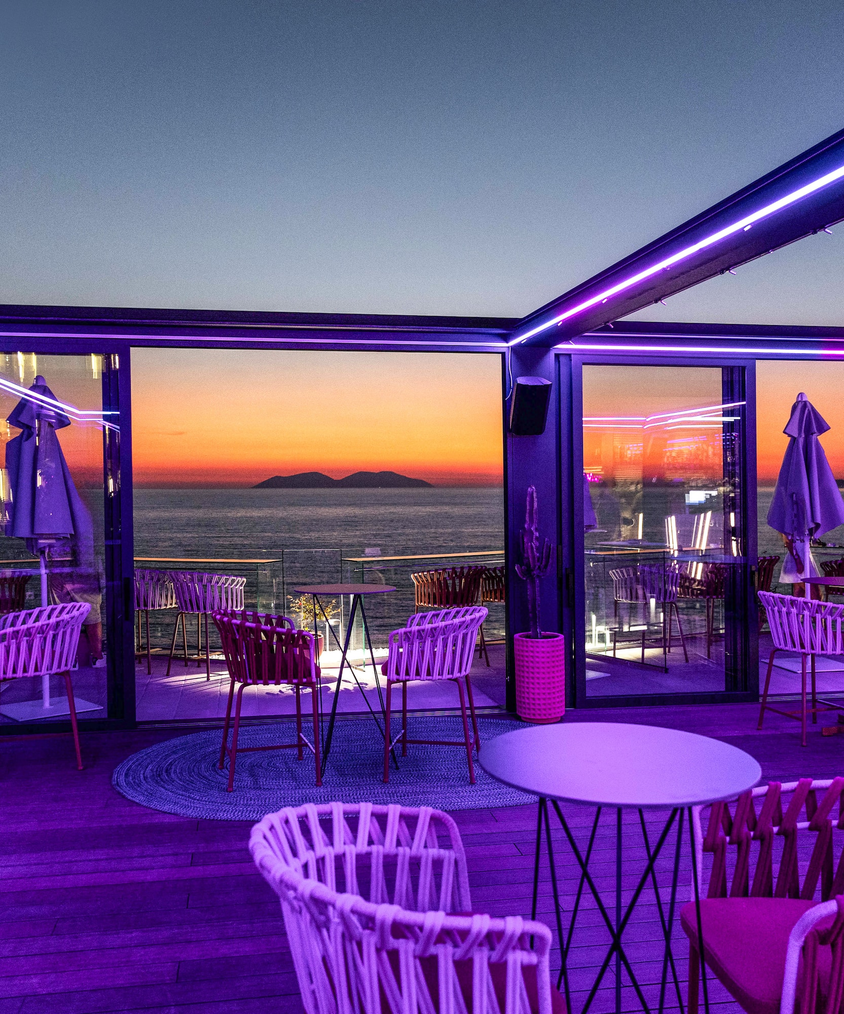 a restaurant with purple lights and chairs