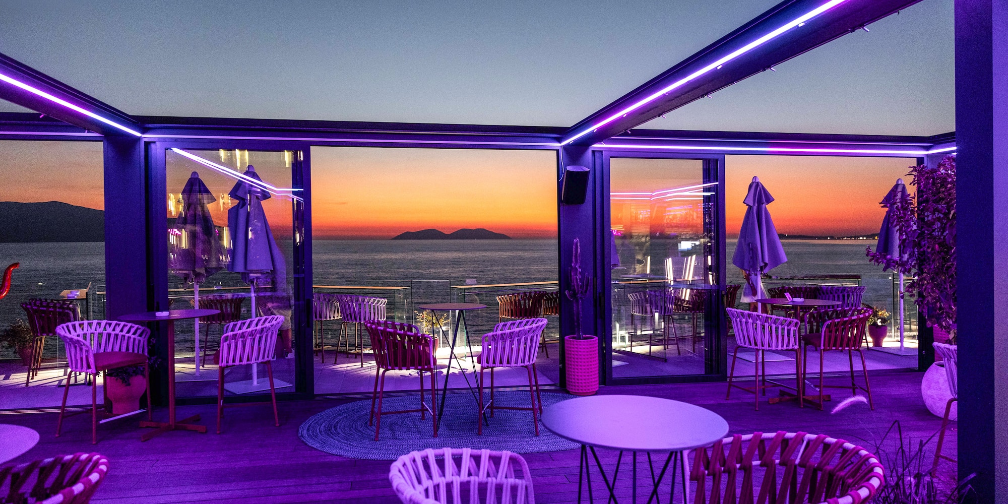 a restaurant with purple lights and chairs