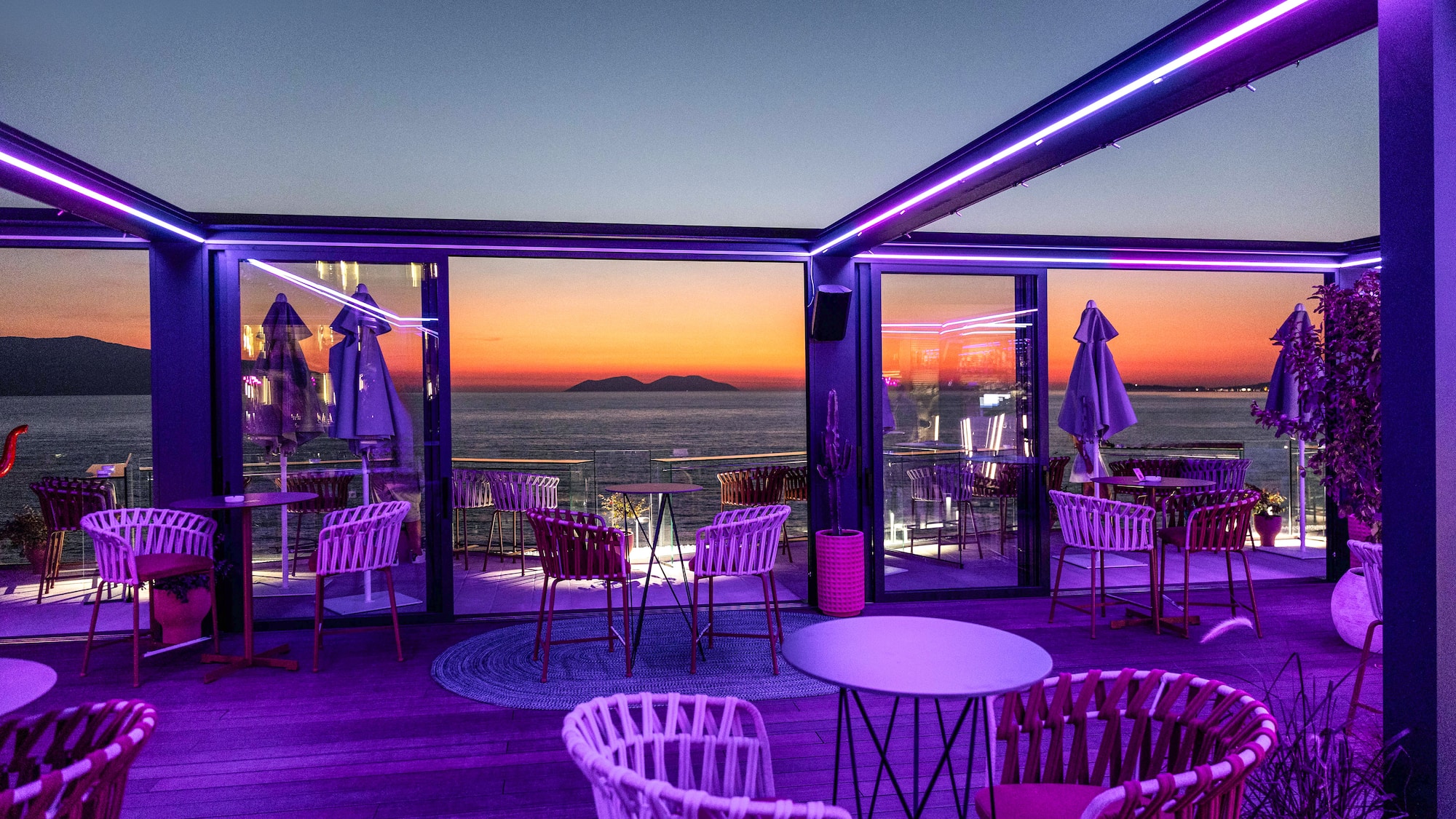 a restaurant with purple lights and chairs