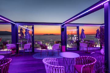 a restaurant with purple lights and chairs