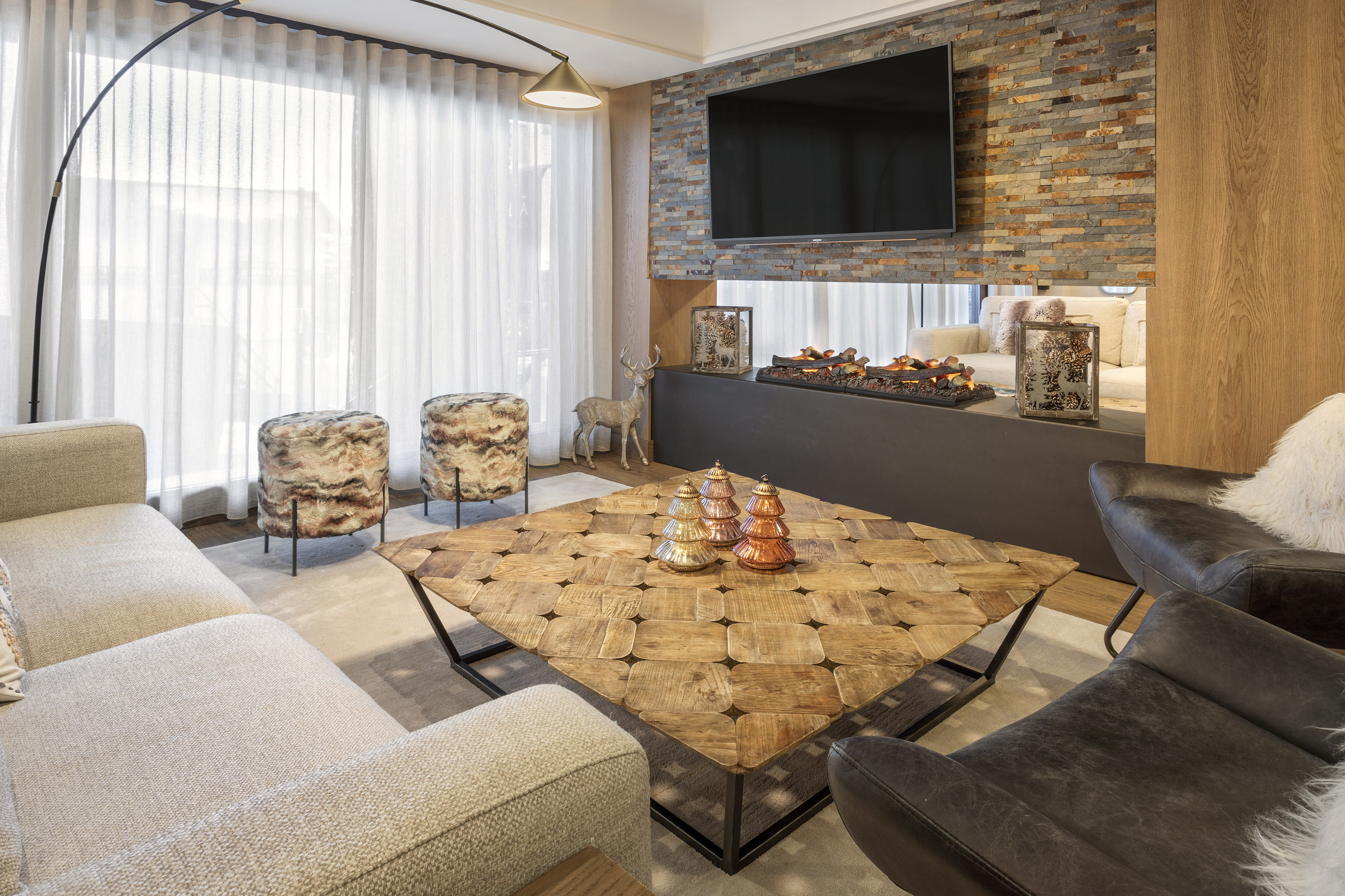 Modern living room with stone wall, electric fireplace, sofa, and wood coffee table.