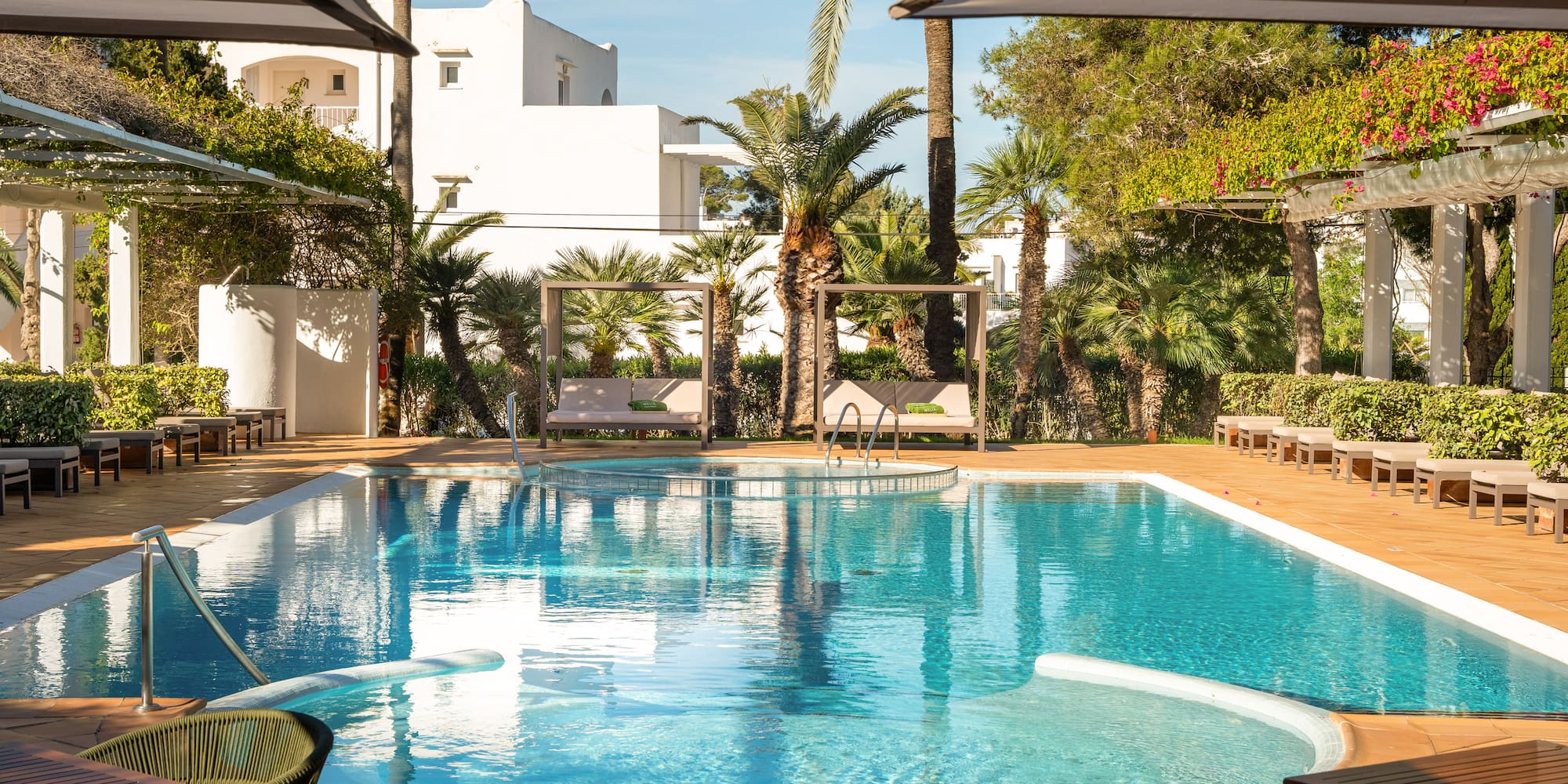 a swimming pool with chairs and umbrellas