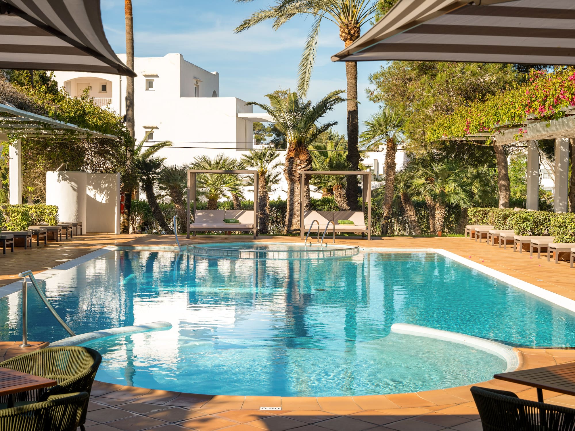 a swimming pool with chairs and umbrellas