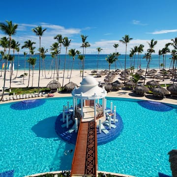 a pool with a gazebo and palm trees