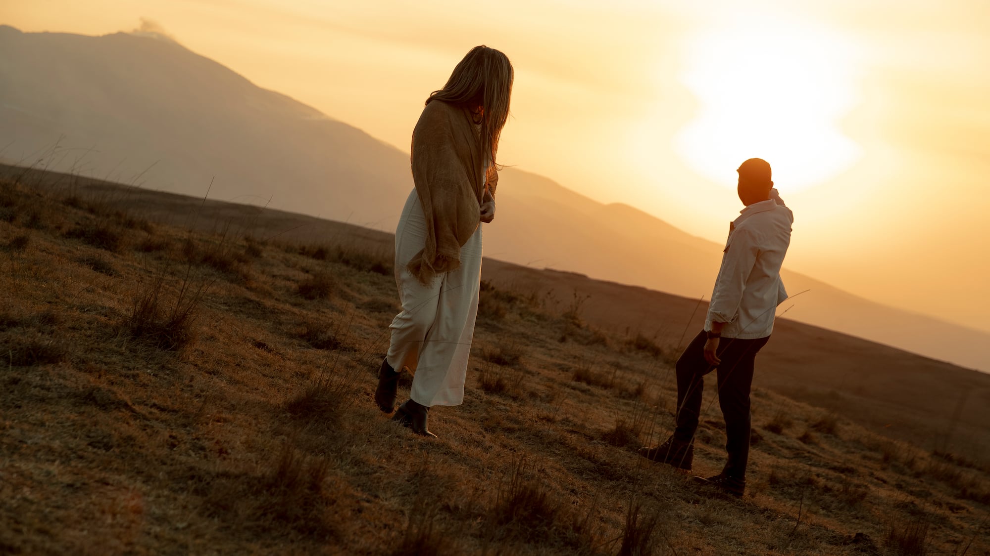 a man and woman walking in a field