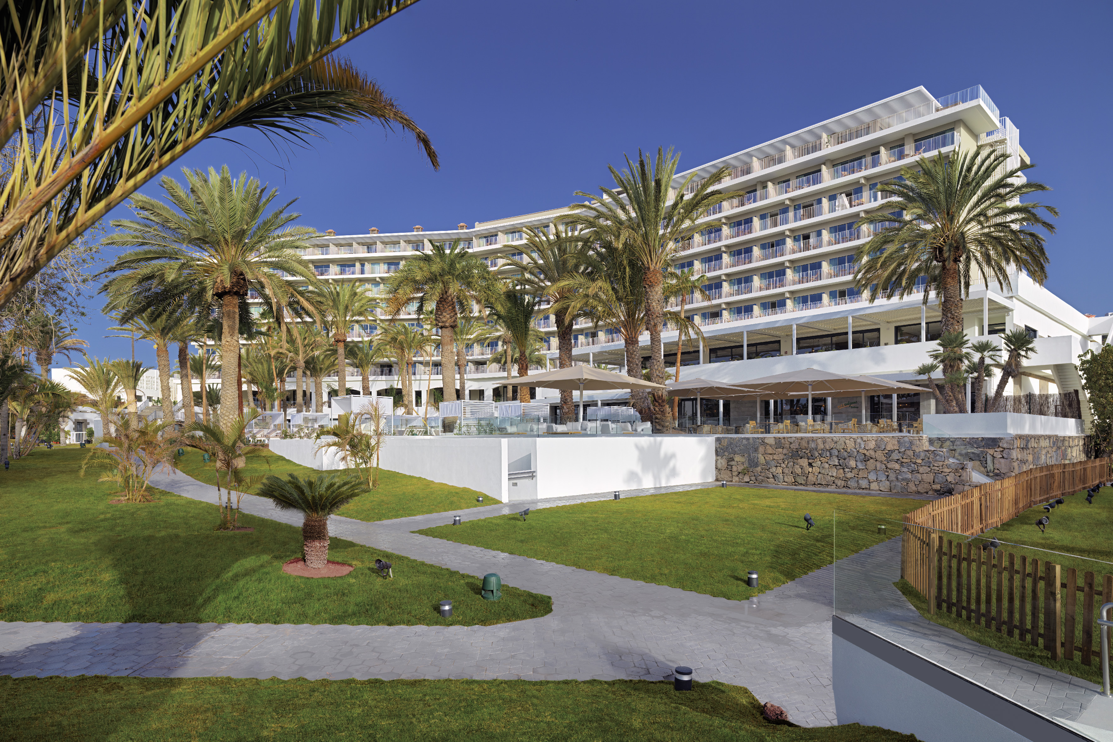 Tropical resort hotel with palm trees and green landscaped gardens.