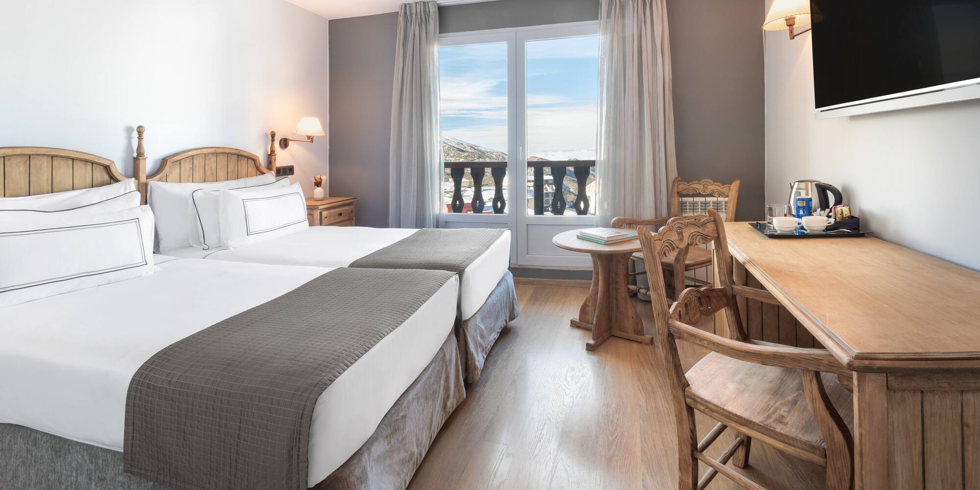 a room with two beds and a table and chairs