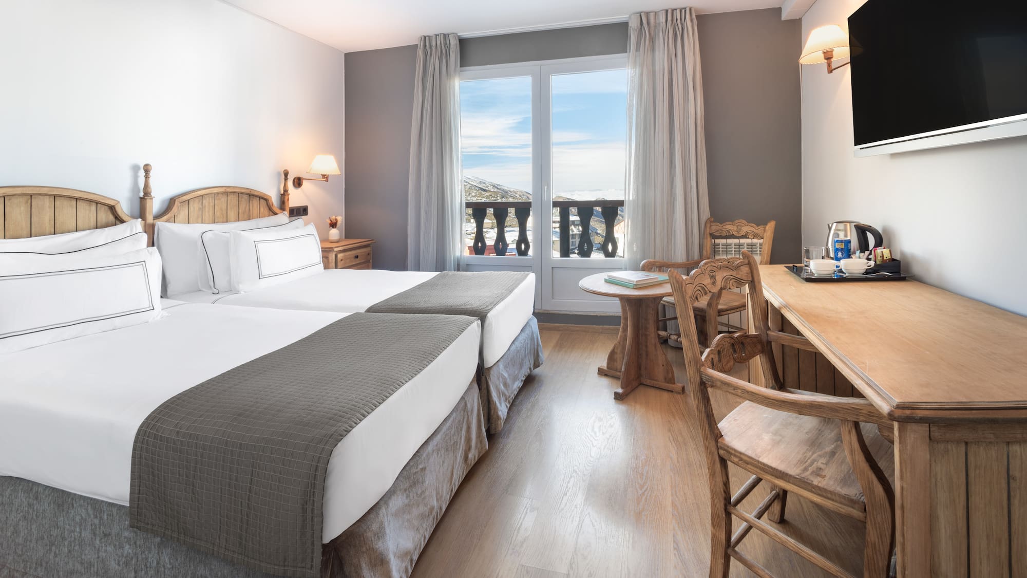 a room with two beds and a table and chairs