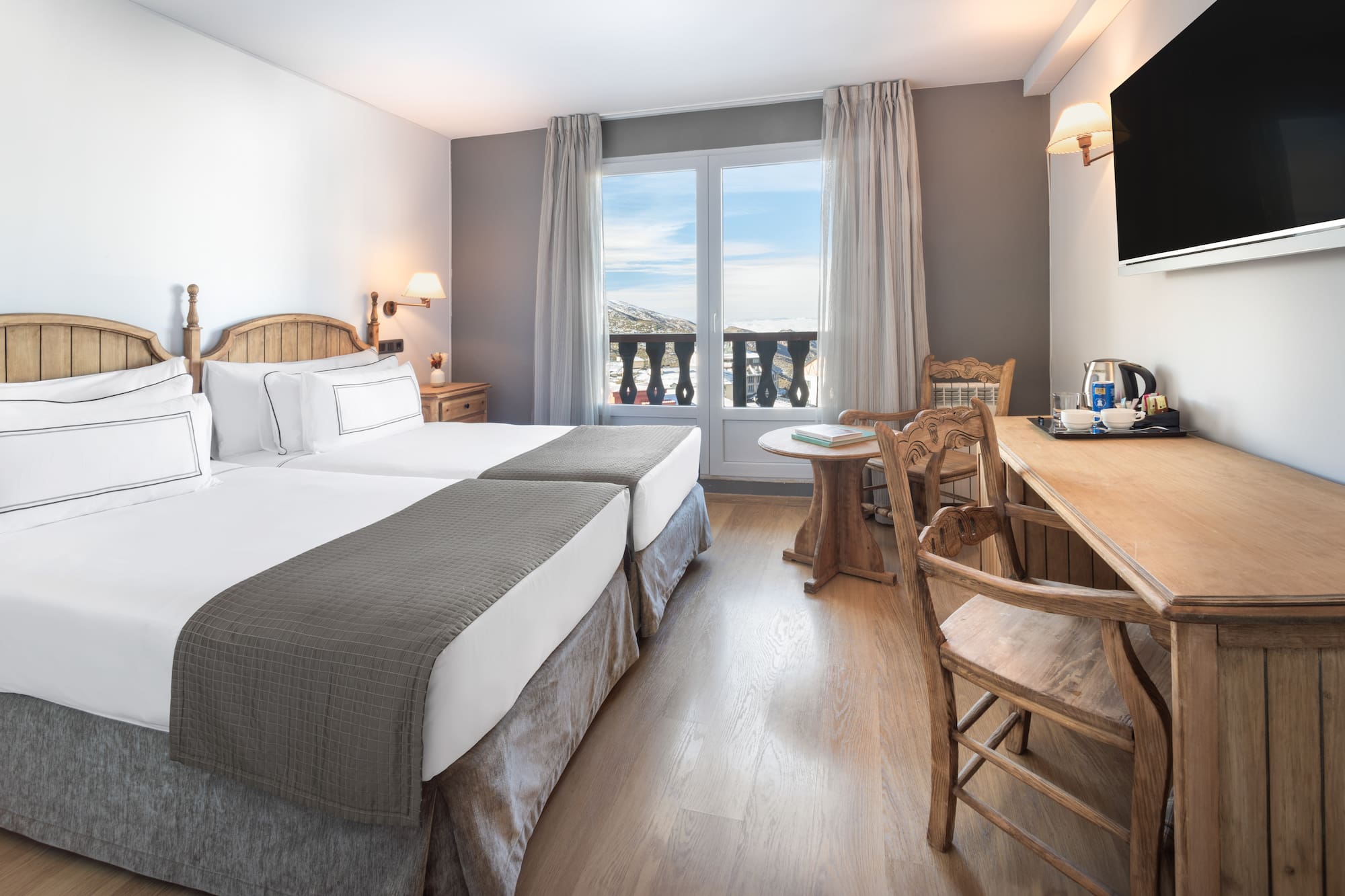 a room with two beds and a table and chairs