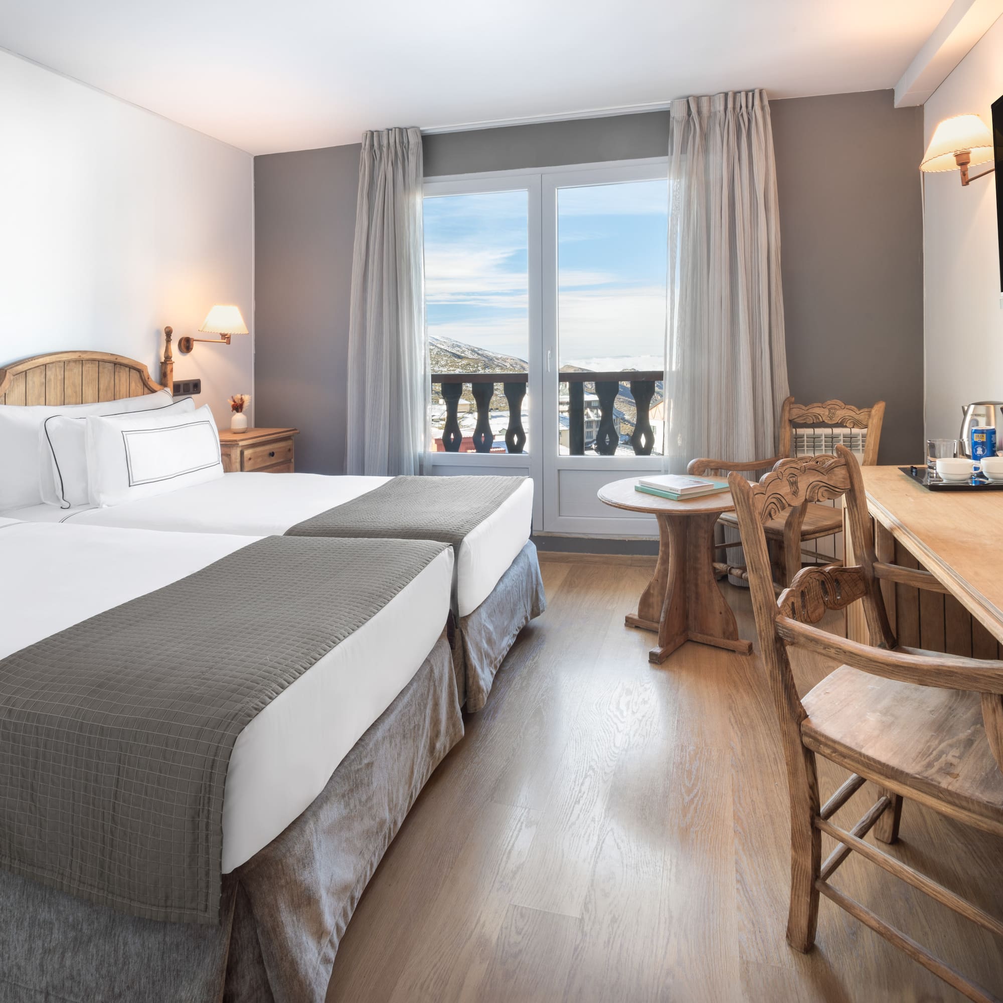 a room with two beds and a table and chairs