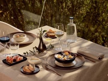 a table with plates of food and glasses of wine