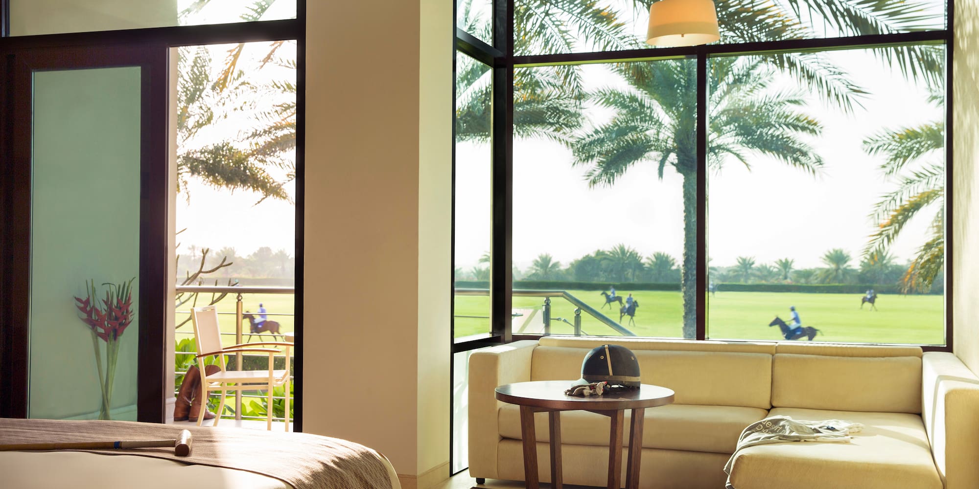 a room with a bed and couches and a table with chairs and a golf course