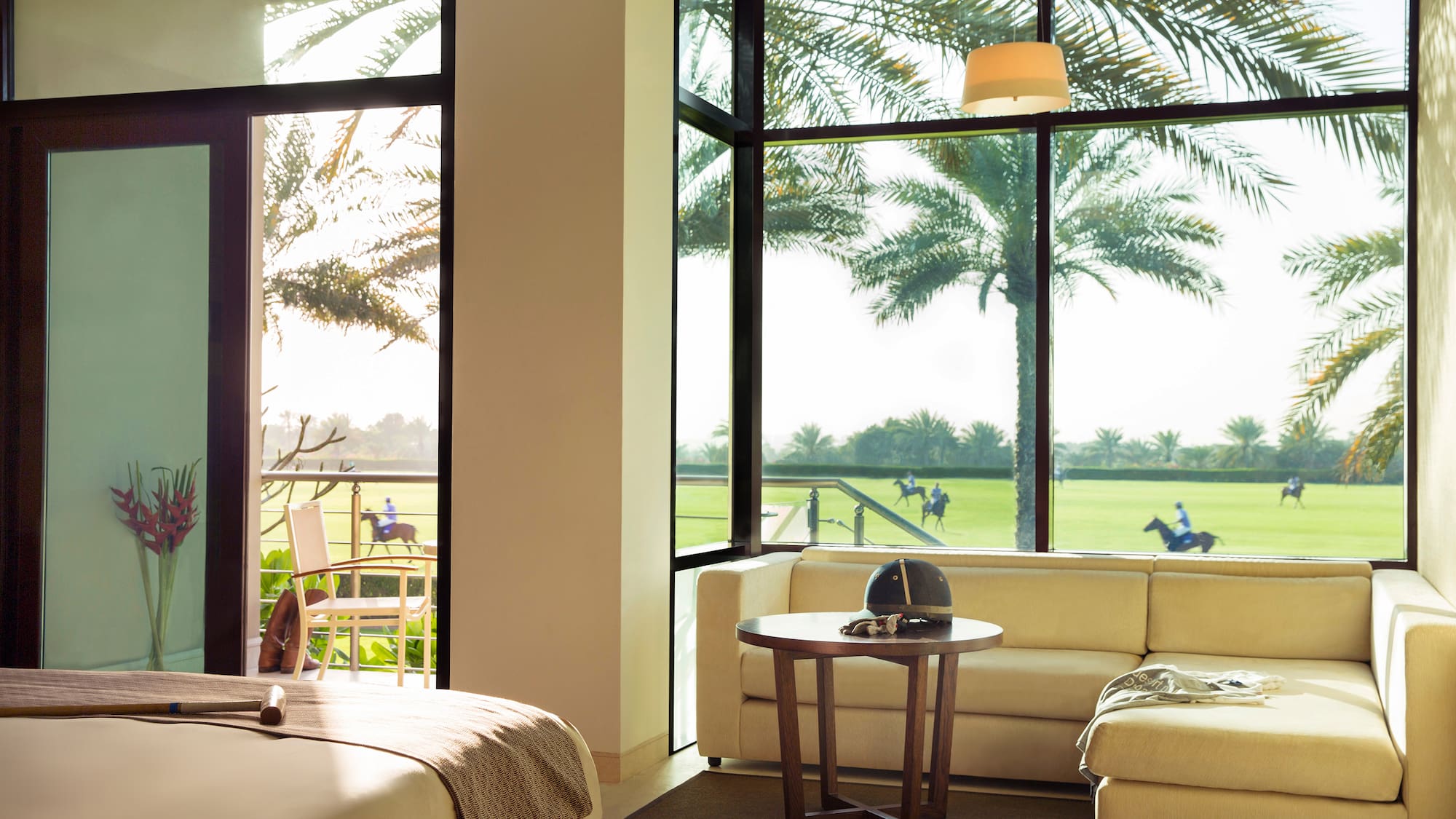 a room with a bed and couches and a table with chairs and a golf course