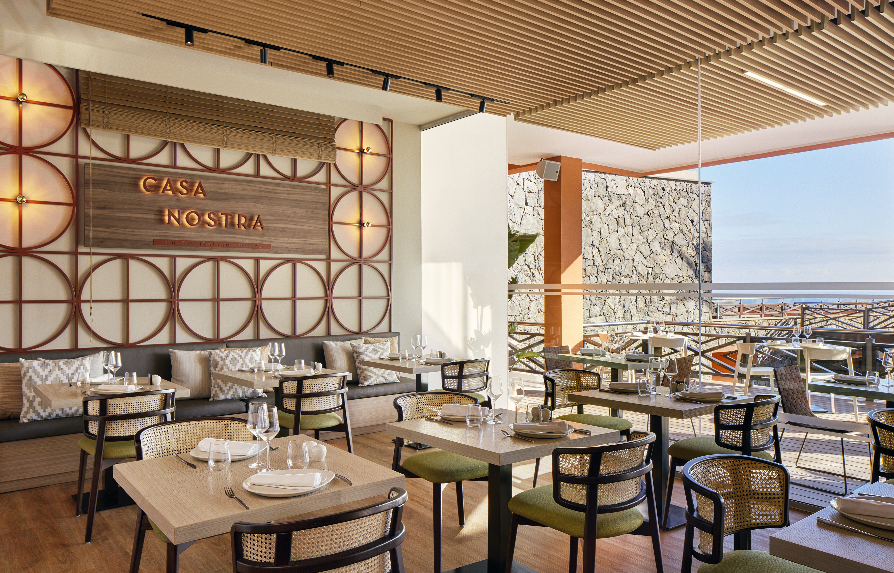 Casa Nostra Italian restaurant interior, modern decor, wooden ceiling, and ocean view.