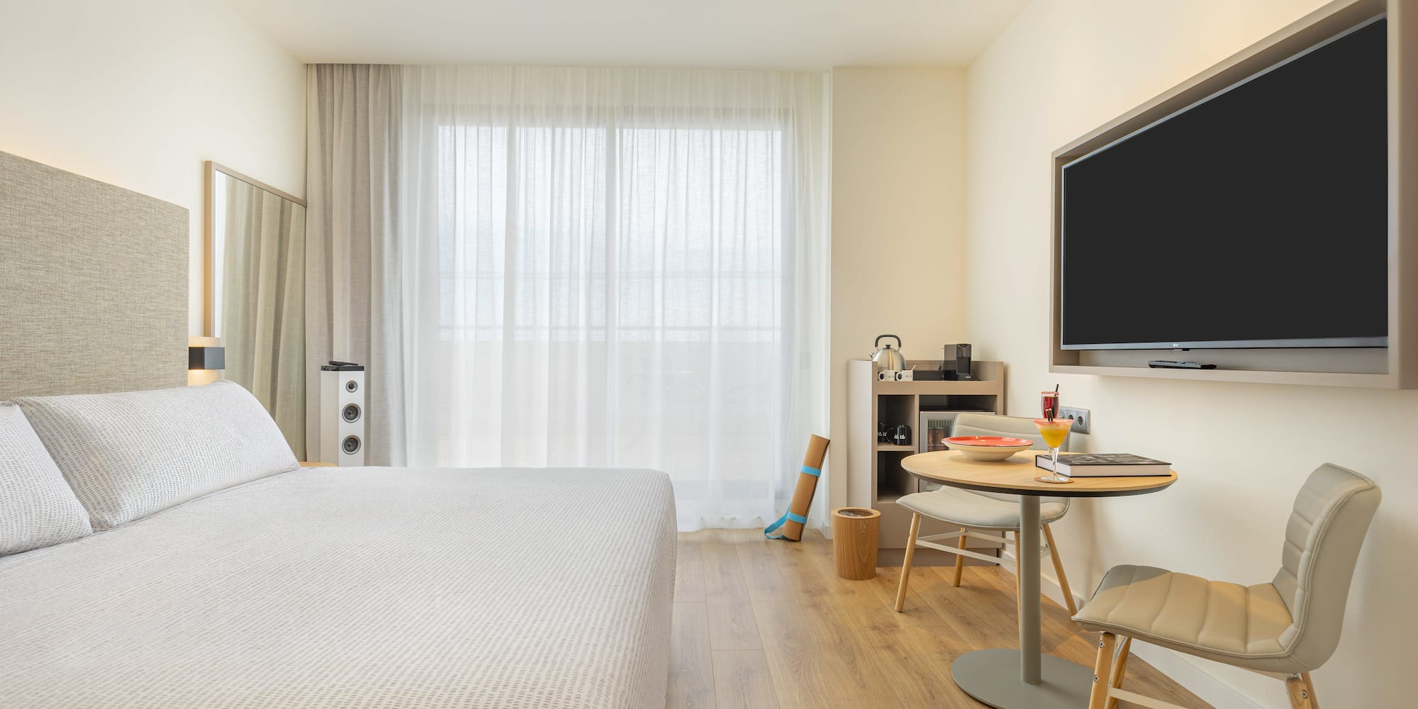 a room with a bed and a table and a tv