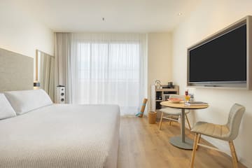 a room with a bed and a table and a tv