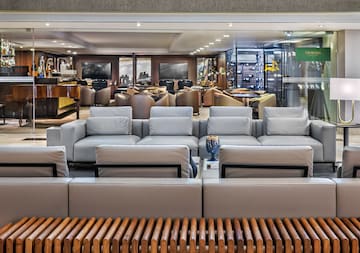 Churchill Lounge Bar interior with grey sofas, grand piano, and wine cellar.