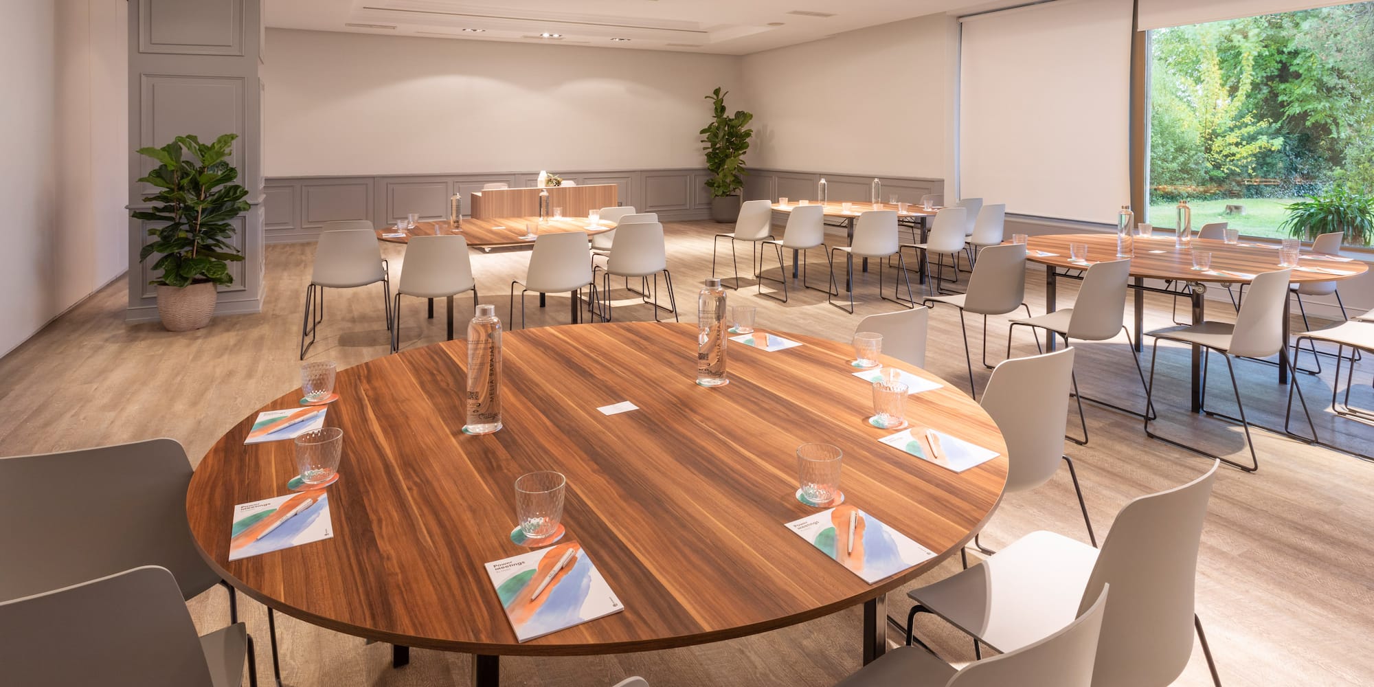 a room with a large round table and chairs