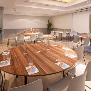 a room with a large round table and chairs