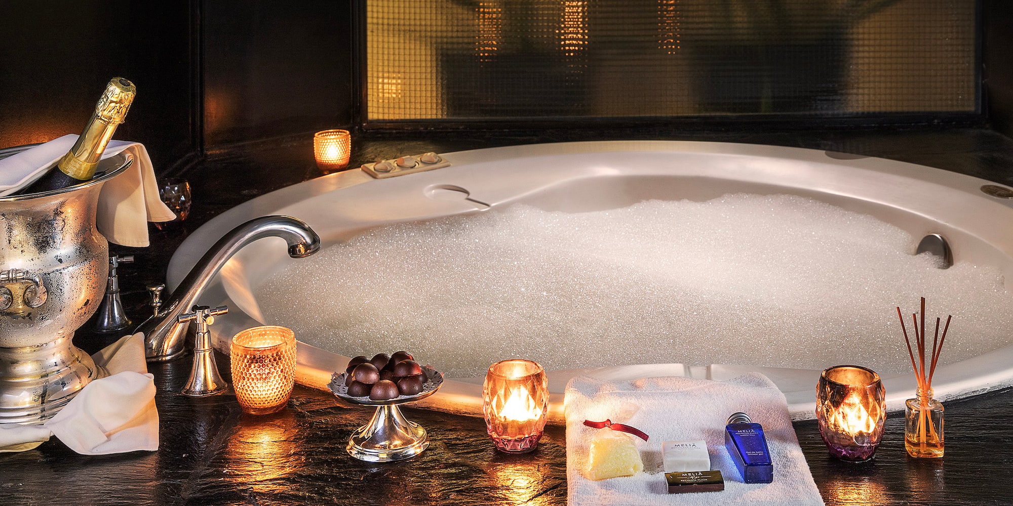 a bathtub with candles and soaps