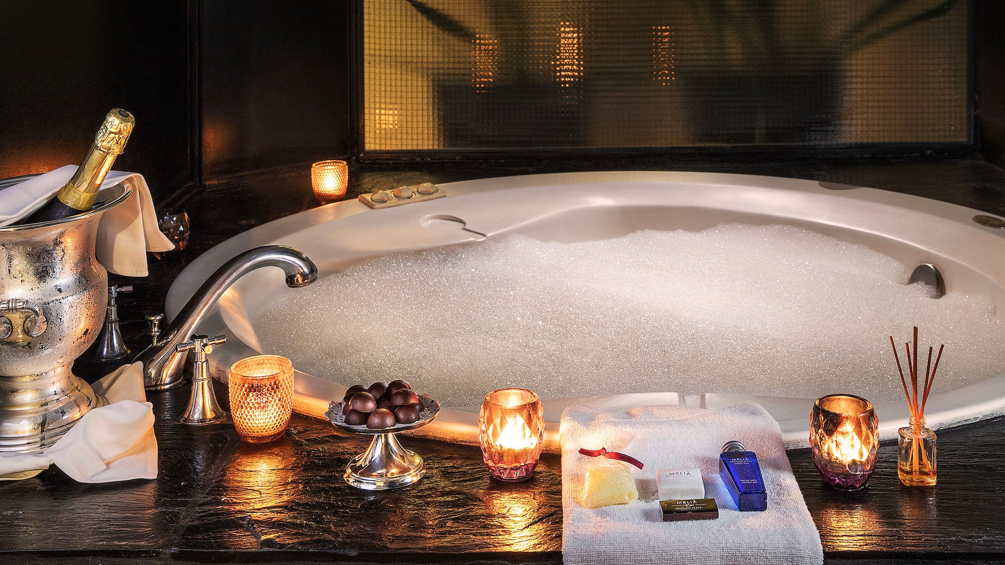 a bathtub with candles and soaps