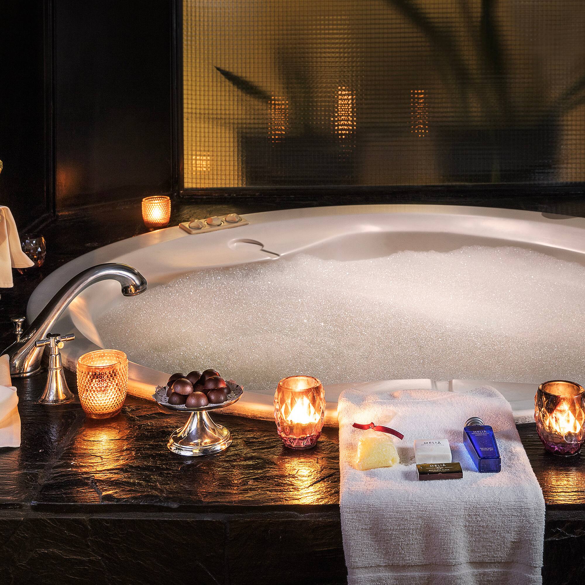 a bathtub with candles and soaps