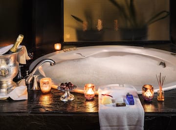 a bathtub with candles and soaps