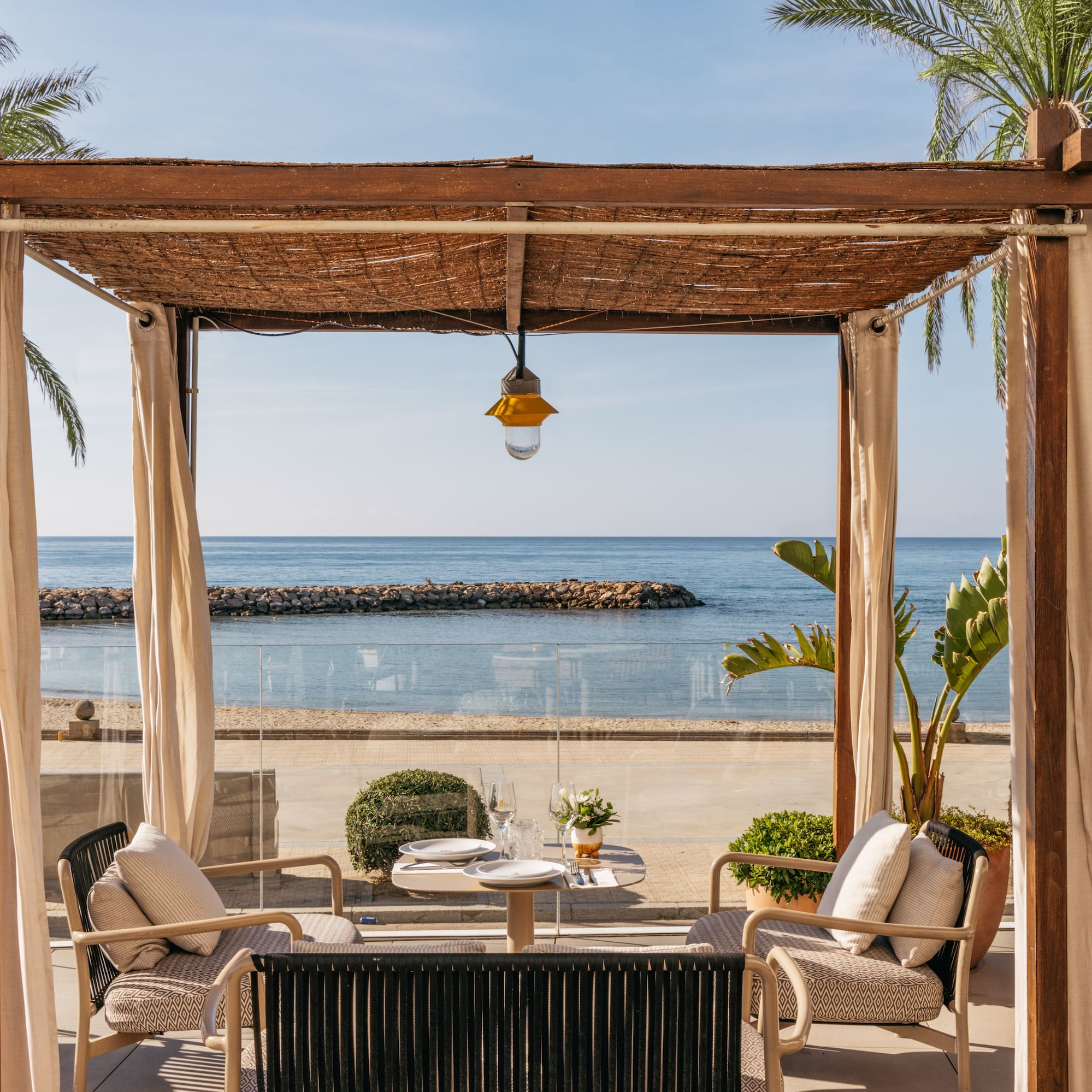 a patio with a table and chairs on a beach