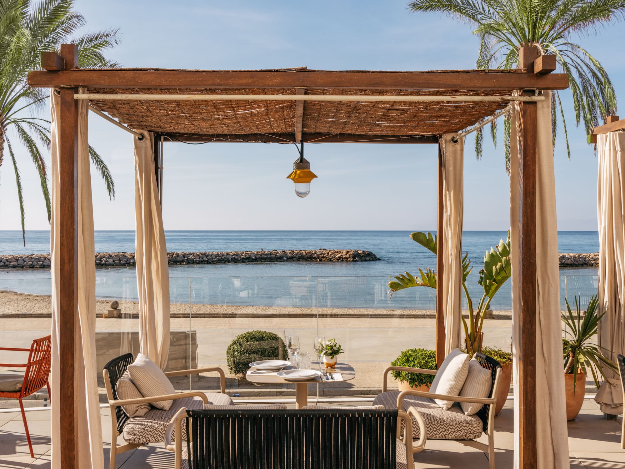 a patio with a table and chairs on a beach