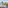 Balcony view of a tropical beach, palm trees, turquoise ocean, and distant island.
