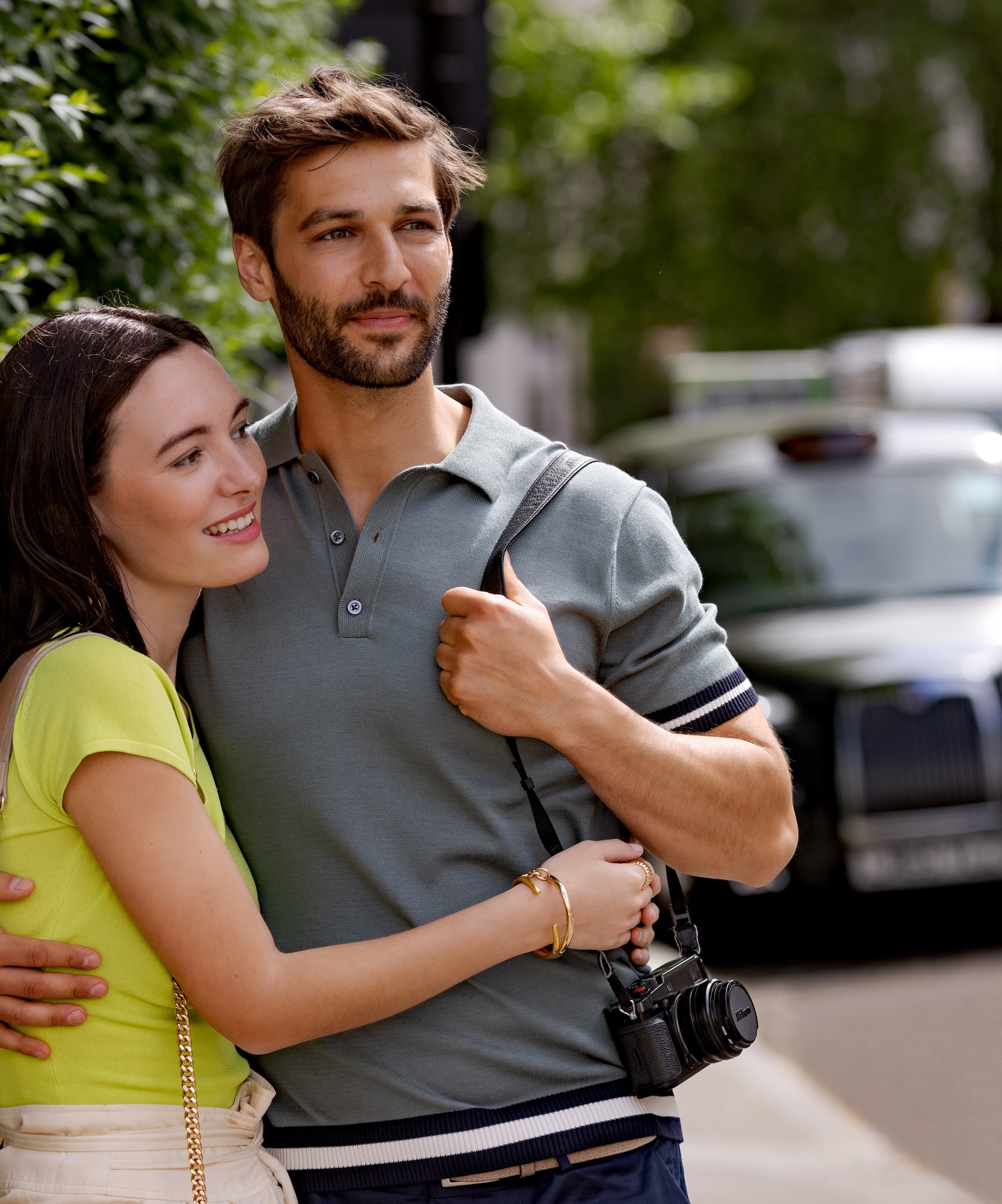 a man and woman hugging on a sidewalk