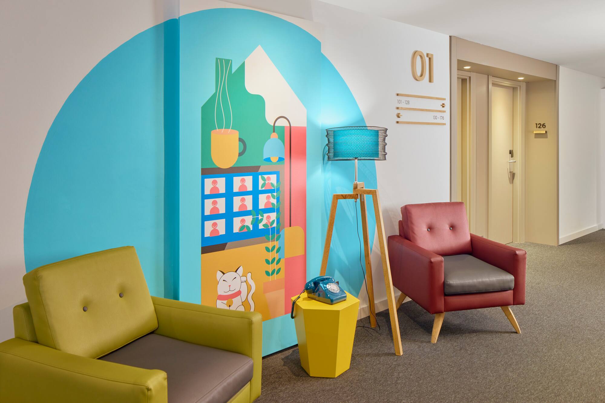 Hotel lobby with vibrant mural, armchairs, tripod lamp, and vintage phone.